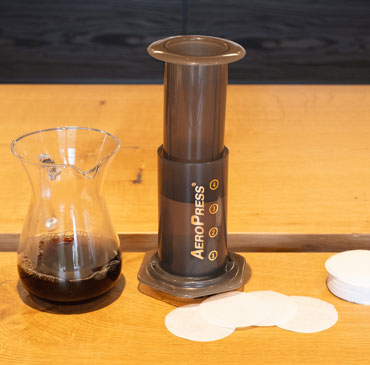 Nachhaltige Kaffeezubereitungsmethoden AeroPress AeroPress Kaffeepresse auf Holzuntergrund