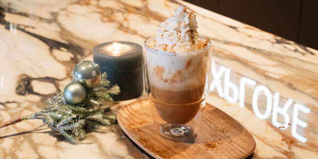 Kaffee-Latte Getränk im Glas mit Sahne und Gewürz