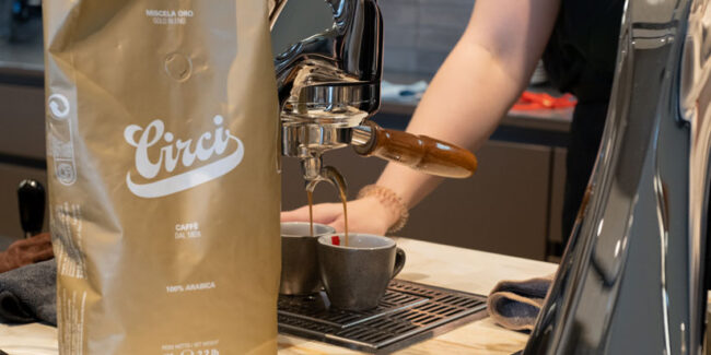Kaffeeverpackung steht vor einer Siebträgermaschine