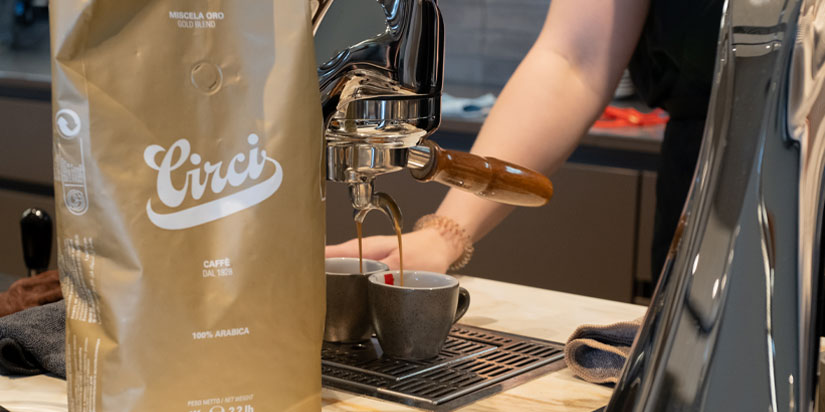 Kaffeeverpackung steht vor einer Siebträgermaschine