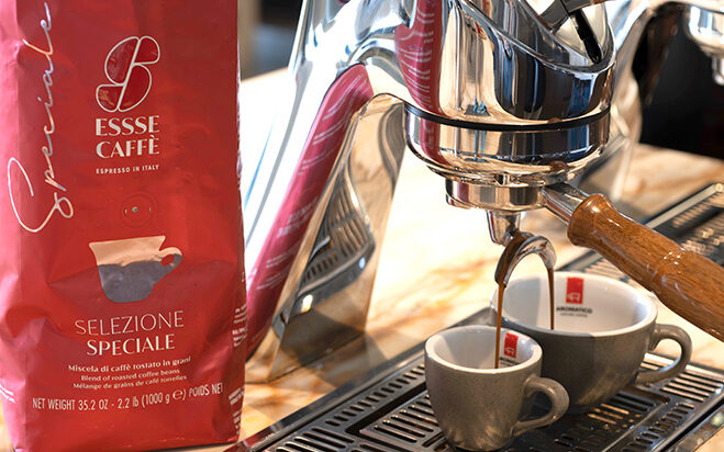 Espresso fließt aus Siebträger in zwei Tassen. Daneben steht die Verpackung Essse Selezione Speciale